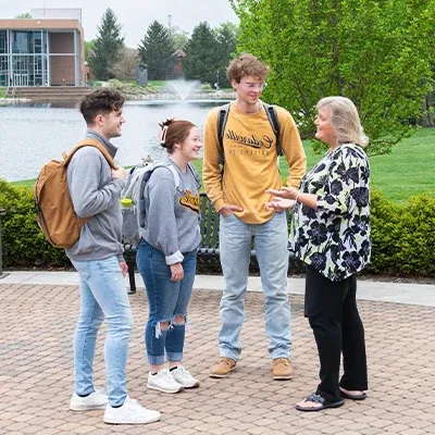 Professor talking with students outside.